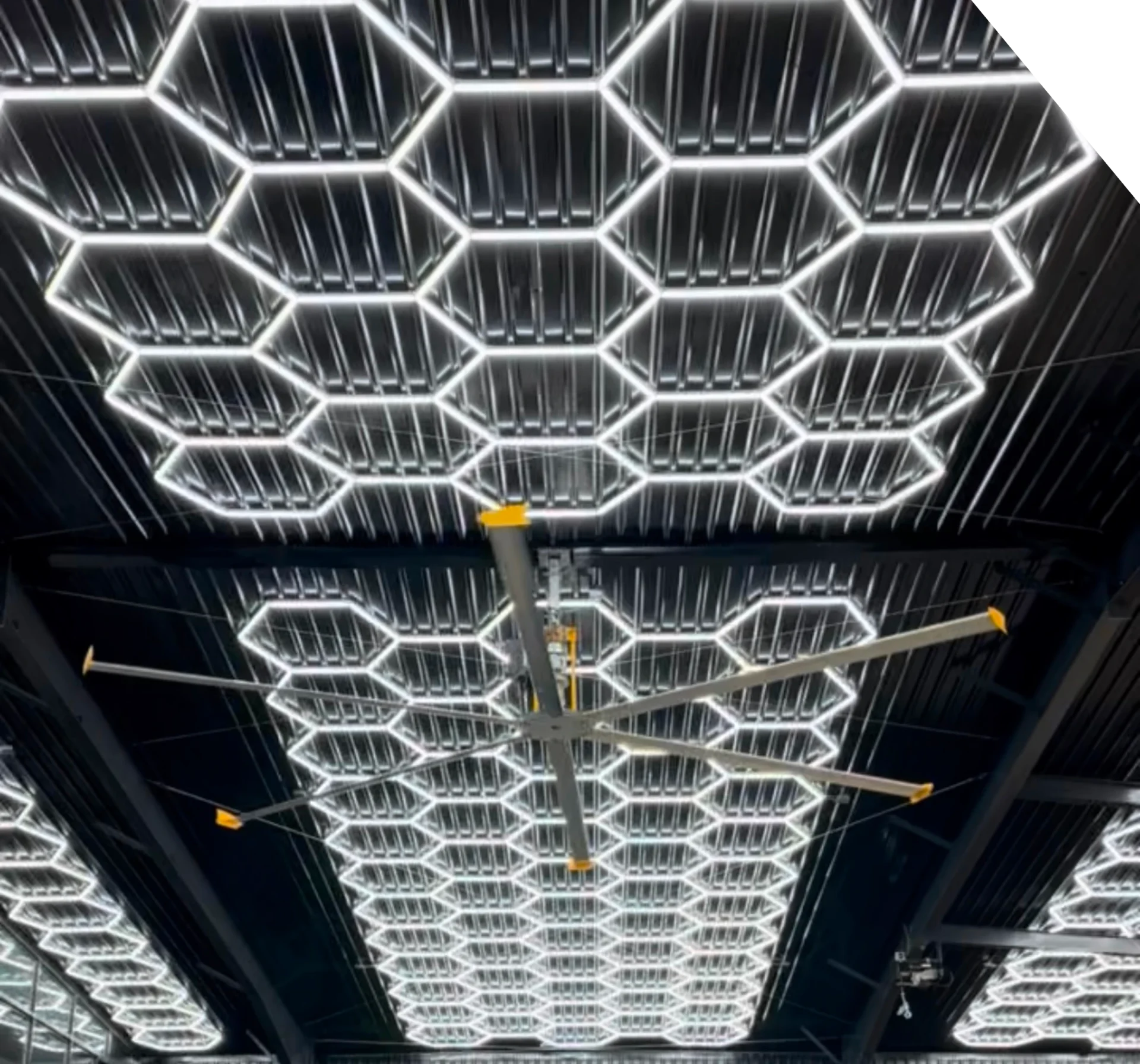 Modern ceiling with illuminated hexagonal light fixtures.